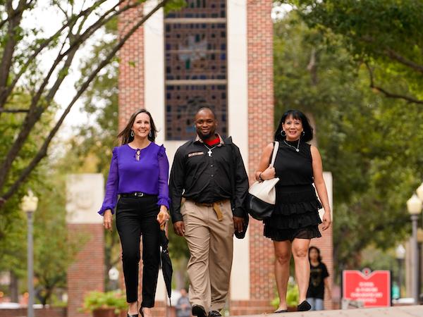 Three students walking across UIW's main campus